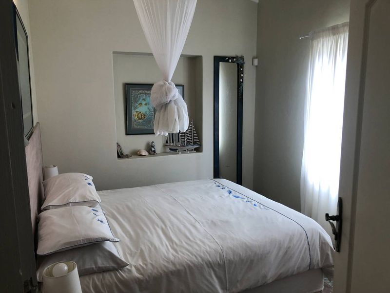 A cozy bedroom featuring a built-in wall niche for display and a window with natural light.