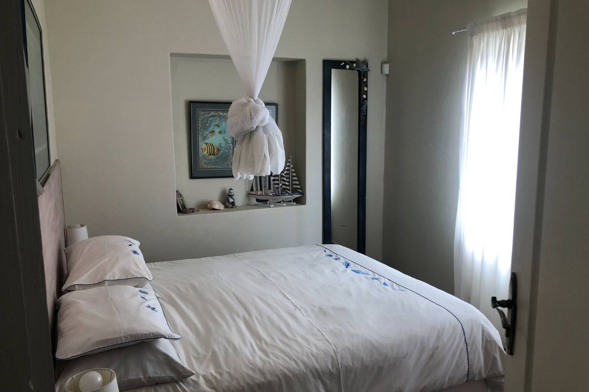 A cozy bedroom featuring a built-in wall niche for display and a window with natural light.