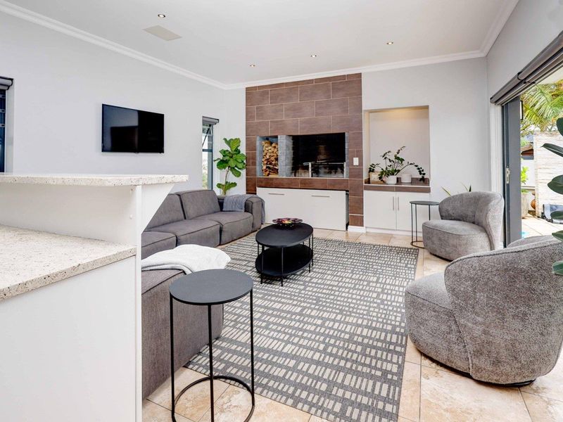 Spacious living room featuring a built-in fireplace with tiled surround, recessed lighting, and large sliding glass doors opening to the outdoor area.