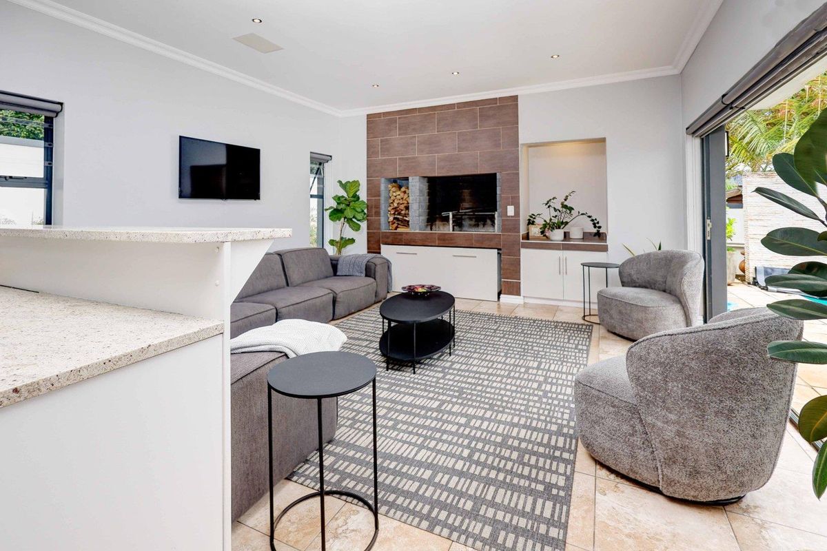 Spacious living room featuring a built-in fireplace with tiled surround, recessed lighting, and large sliding glass doors opening to the outdoor area.