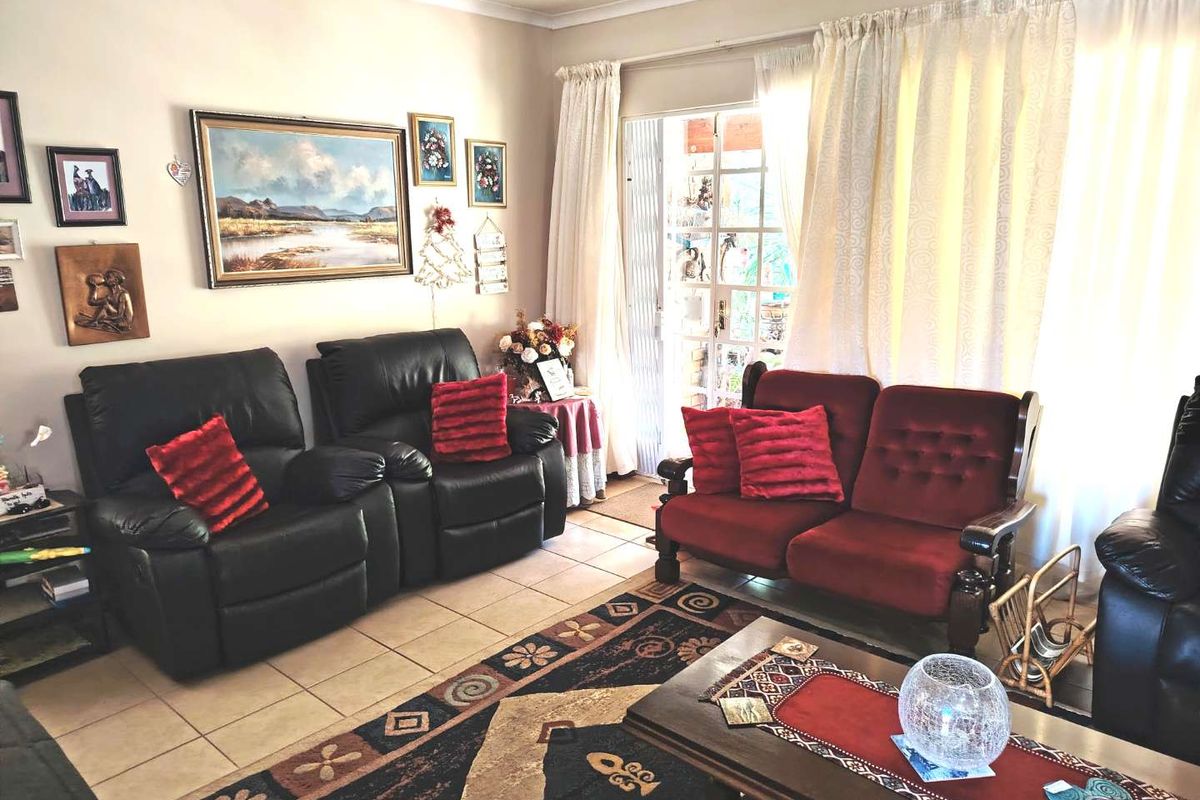 A comfortable living room featuring tiled flooring and a sliding glass door providing access to the outdoor area.