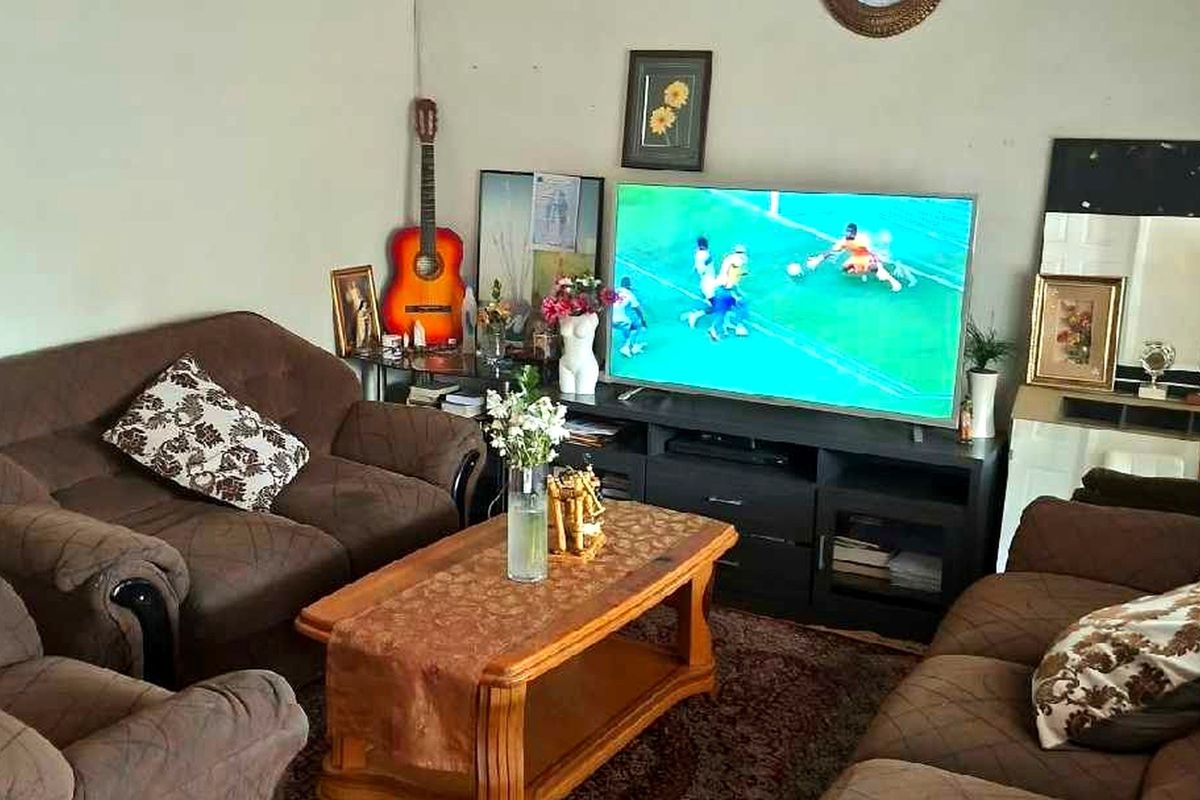 A living room area featuring standard wall finishes and flooring, suitable for modernization and updated interior design.
