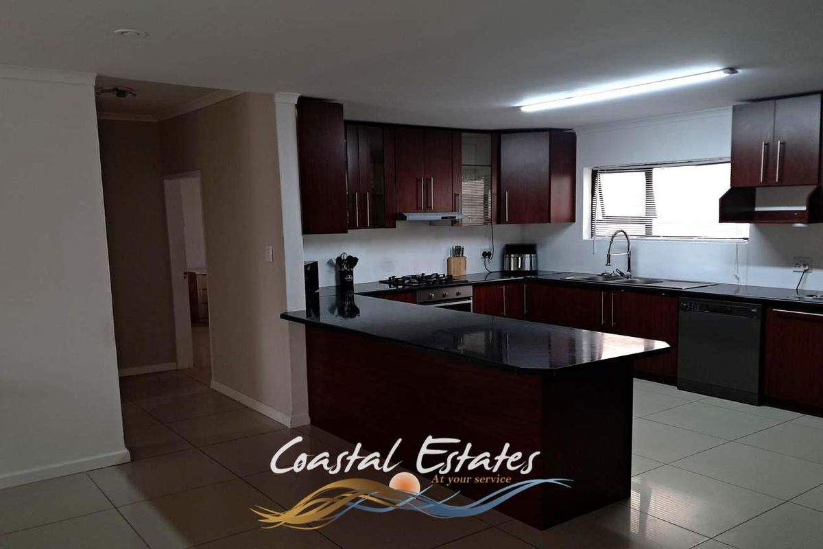 A functional kitchen featuring dark wood cabinetry, granite countertops, a built-in oven, gas hob, and tiled flooring.
