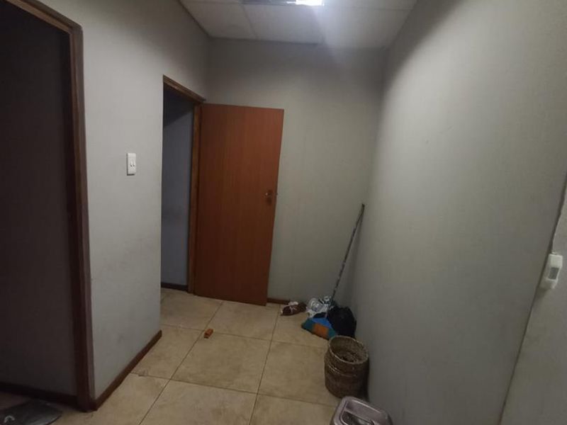 A functional hallway featuring tiled flooring and standard internal doors, providing access to multiple rooms within the business premises.