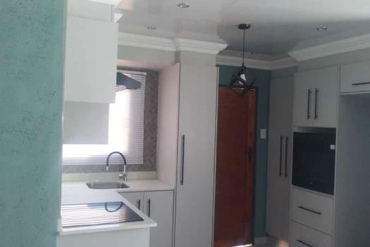 Modern kitchen featuring sleek cabinetry, integrated oven, built-in hob, and a contemporary sink with a stylish faucet.