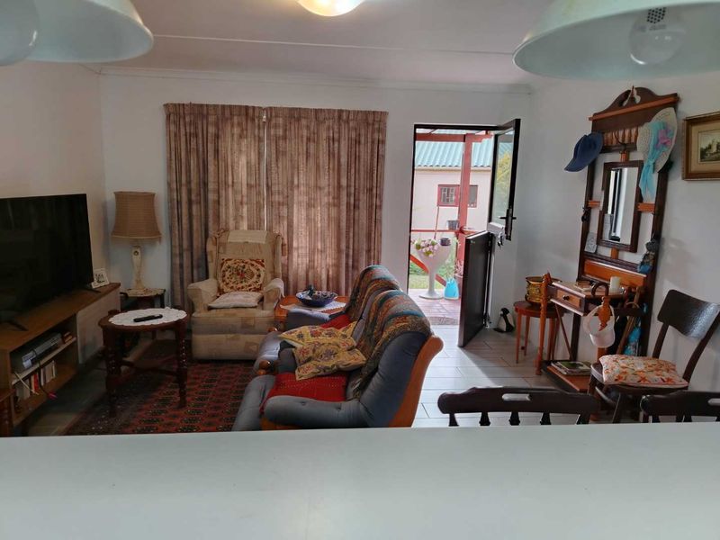 A cozy living room featuring tiled flooring and a stable door providing direct access to the outdoor patio area.
