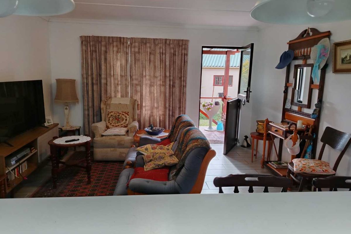 A cozy living room featuring tiled flooring and a stable door providing direct access to the outdoor patio area.