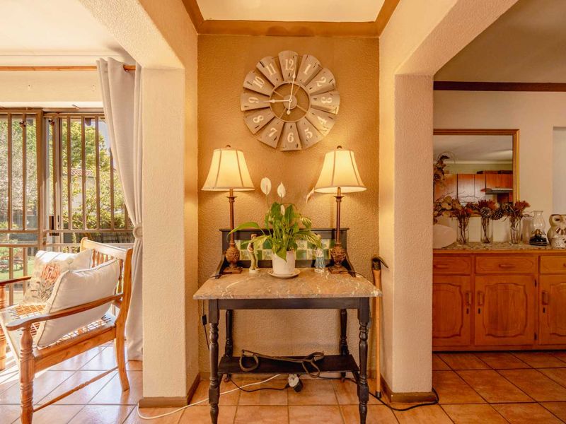 A welcoming hallway featuring tiled flooring, built-in wooden cabinetry, and access to an outdoor area through a sliding glass door with security gate.