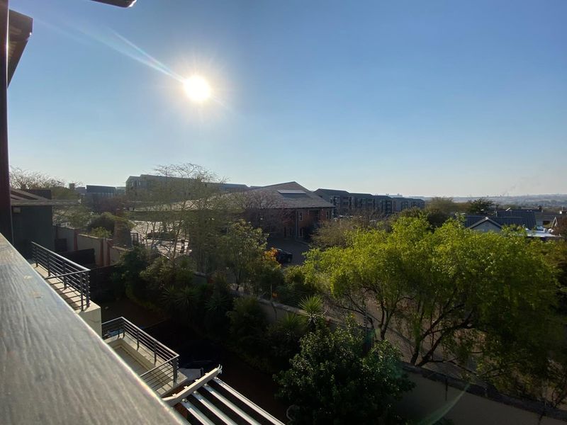 Elevated view overlooking the surrounding residential complex and landscaped grounds from a private balcony.