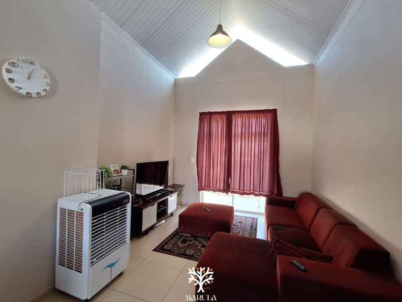 Spacious living room featuring a high vaulted ceiling, tiled flooring, and a sliding glass door providing access to the exterior.
