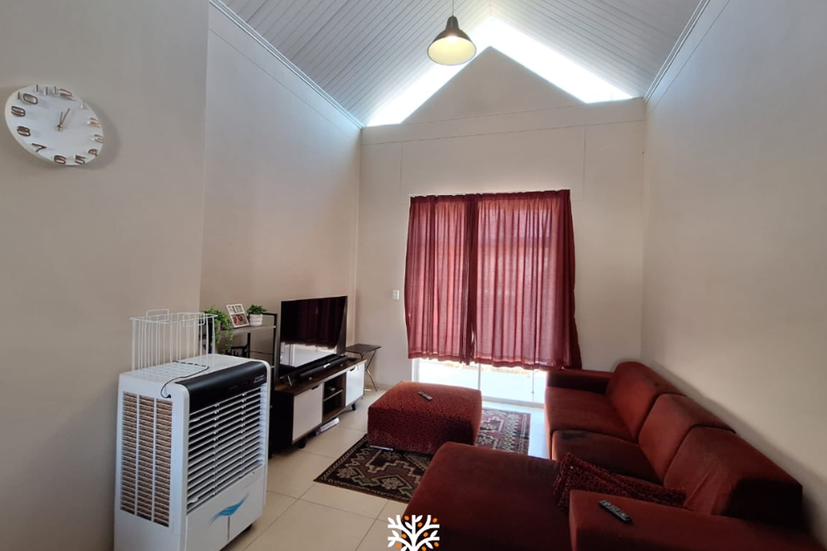 Spacious living room featuring a high vaulted ceiling, tiled flooring, and a sliding glass door providing access to the exterior.