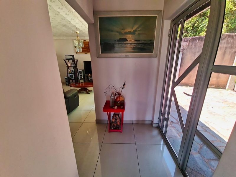 Entrance foyer featuring tiled flooring and an aluminium framed glass door leading to the exterior.
