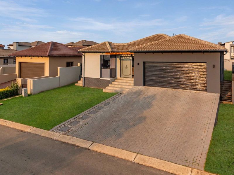 Modern single-story residential home featuring a paved driveway, double garage, and well-maintained front lawn with contemporary architectural finishes.