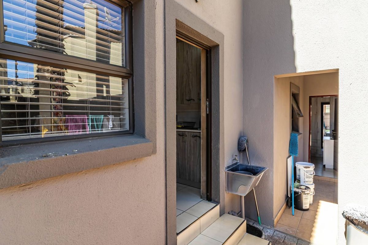 Rear exterior area featuring a utility sink, tiled flooring, and access to the interior of the property.