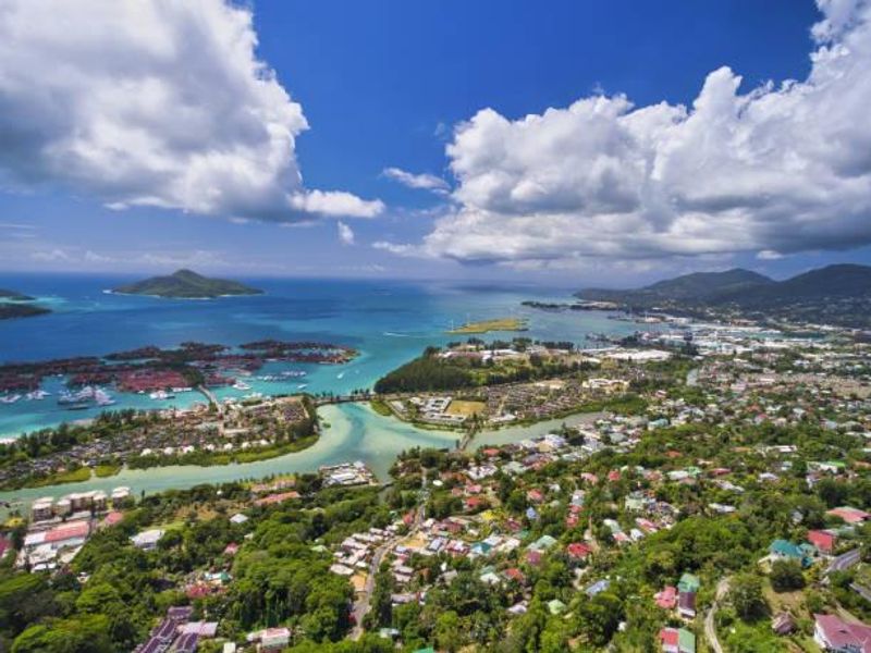 An expansive aerial view of the coastal landscape, showcasing the surrounding residential area, waterways, and distant islands.