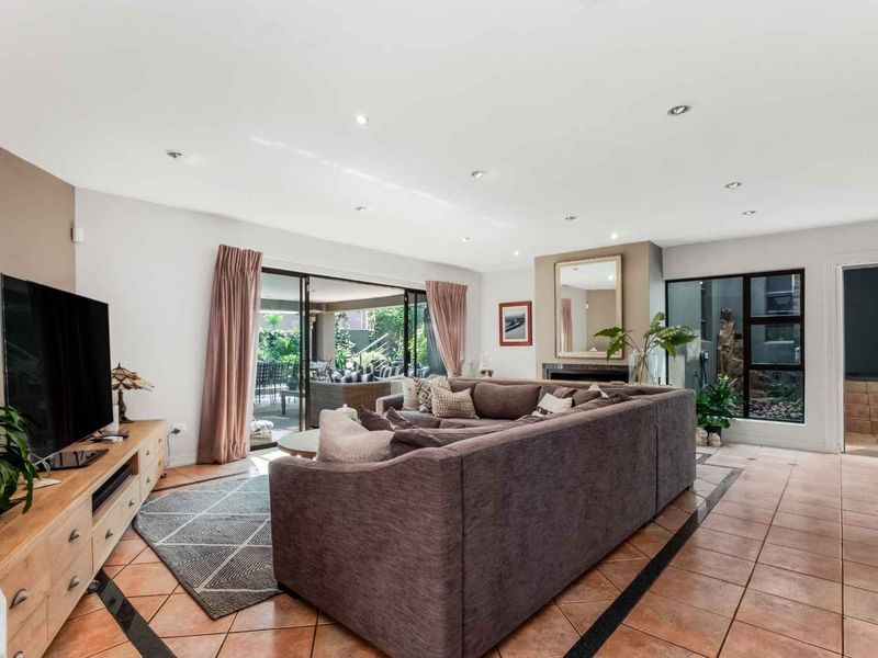 Spacious living room featuring tiled flooring, recessed lighting, a fireplace, and large sliding glass doors providing seamless access to the outdoor patio area.