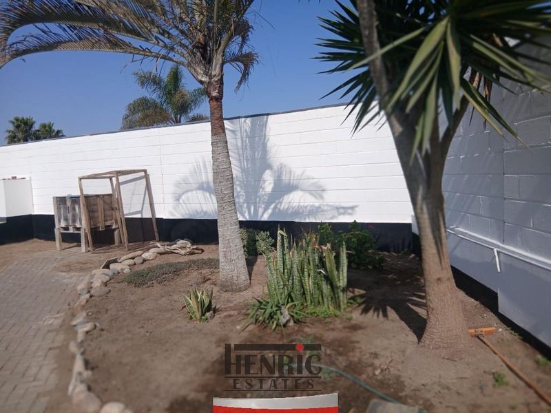 A private garden area featuring a paved walkway and a painted boundary wall.