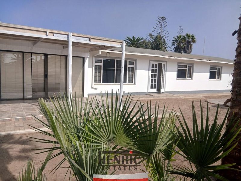Rear view of the property featuring a covered patio area with tiled flooring, sliding glass doors, and access to the backyard.