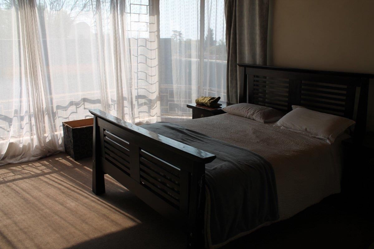 A bedroom featuring carpeted flooring and a large sliding glass door that provides natural light and access to the exterior.