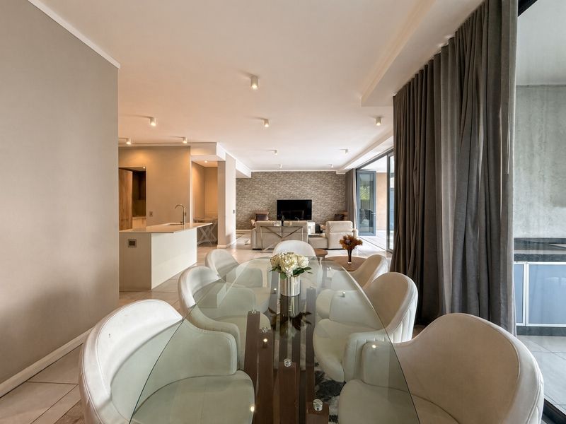 Spacious open-plan living and dining area featuring a stone accent wall, modern kitchen island, and large sliding doors leading to the patio.