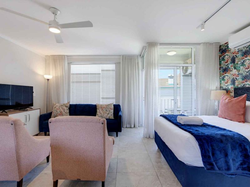 Spacious bedroom featuring tiled flooring, a ceiling fan, split system air conditioning, and direct access to a private balcony through sliding glass doors.