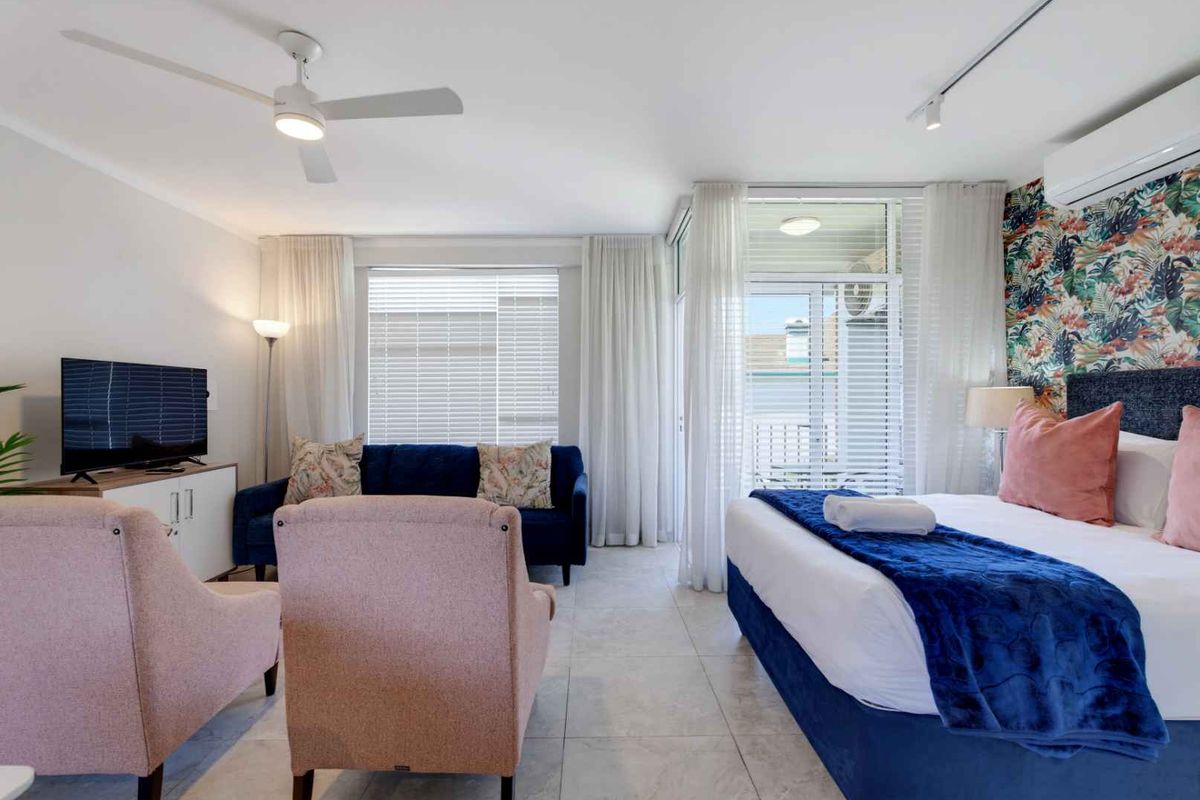 Spacious bedroom featuring tiled flooring, a ceiling fan, split system air conditioning, and direct access to a private balcony through sliding glass doors.