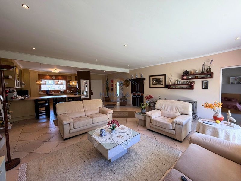 Spacious open-plan living area featuring tiled floors, recessed lighting, and a functional kitchen with a central island and built-in cabinetry.