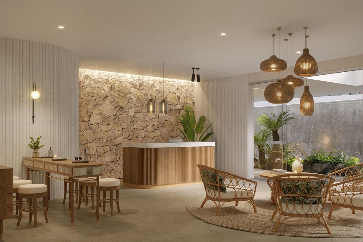 A sophisticated, modern reception or lounge area featuring a natural stone feature wall, integrated lighting, and seamless indoor-outdoor flow to a landscaped courtyard.