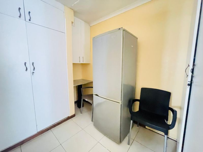 A bedroom featuring built-in cupboards and tiled flooring, providing functional storage space within the apartment.