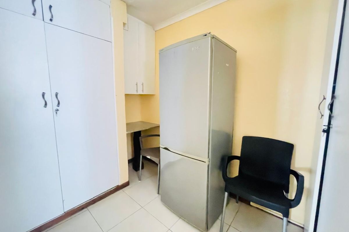 A bedroom featuring built-in cupboards and tiled flooring, providing functional storage space within the apartment.