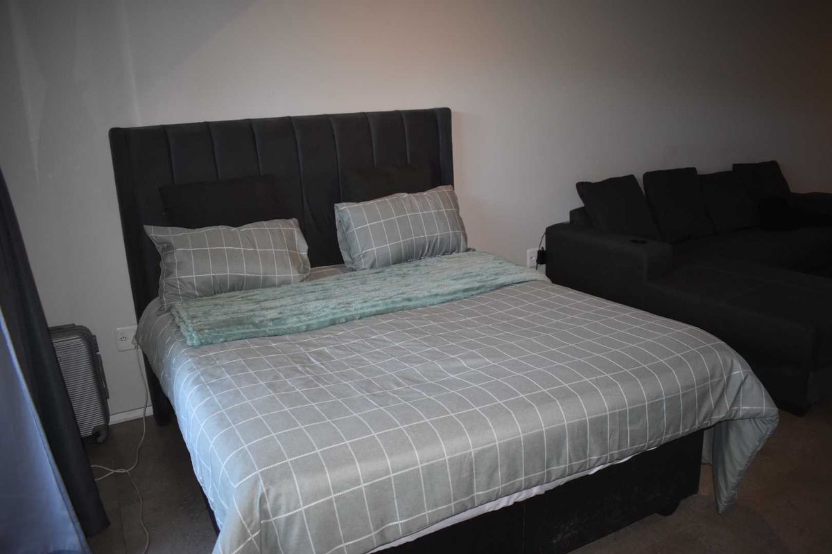 A bedroom featuring a neutral color palette with a built-in headboard and simple interior finishes.
