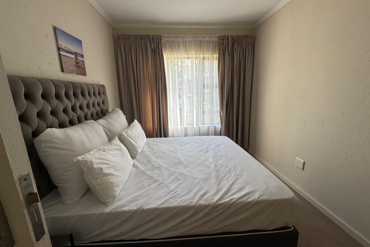 A bedroom featuring textured walls, neutral curtains, and standard electrical fixtures. The space requires minor cosmetic attention to wall finishes.
