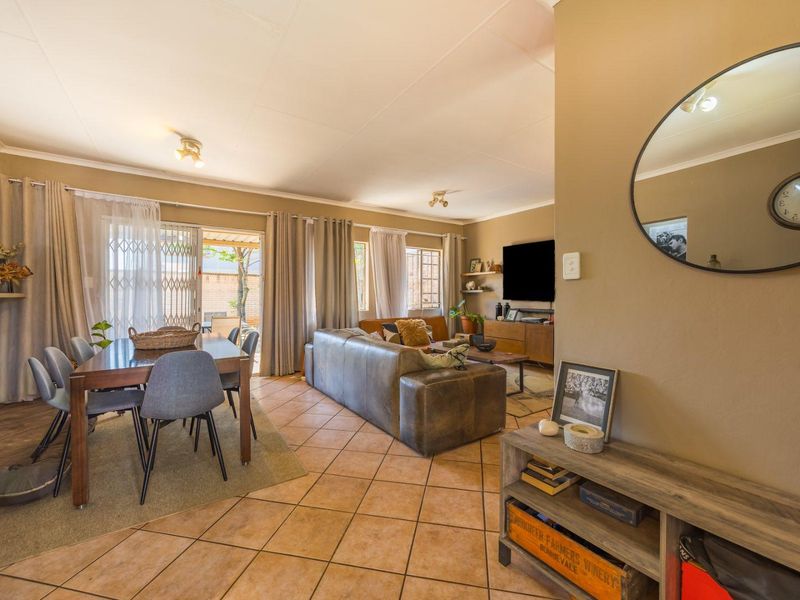 Spacious open-plan living and dining area featuring tiled flooring and direct access to the outdoor patio through a sliding glass door.