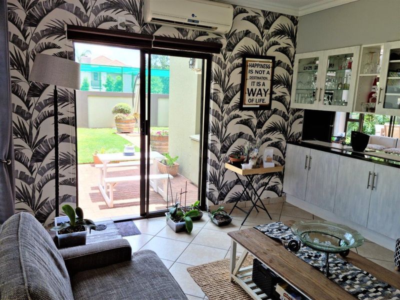 Living room featuring tiled flooring, built-in cabinetry, and a sliding glass door providing direct access to the outdoor patio area.