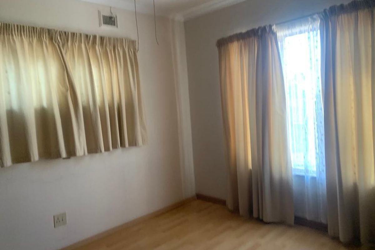 An empty bedroom featuring laminate flooring and neutral wall finishes, offering a blank canvas for personalization.