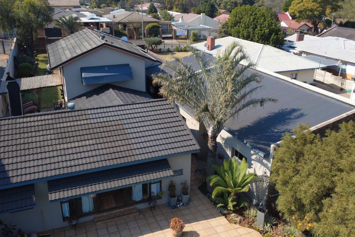 Aerial view of the property showing the tiled roof structure, paved patio area, and surrounding residential neighbourhood.