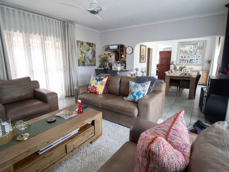 Spacious open-plan living and dining area featuring tiled flooring, a wood-burning fireplace, and direct access to the outdoors through sliding glass doors.
