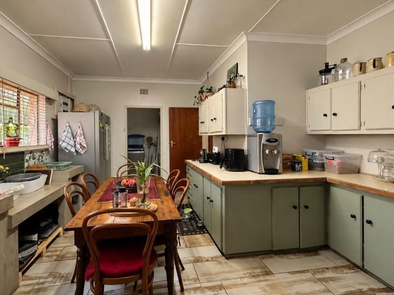 A functional kitchen featuring built-in cabinetry, concrete countertops, and tiled flooring, offering a practical layout with potential for modern updates.