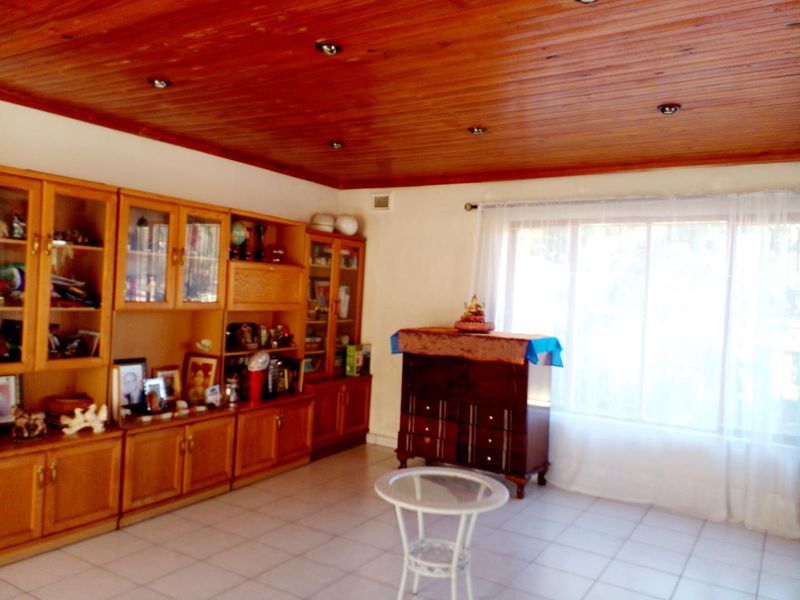 Living room featuring tiled flooring, a timber tongue and groove ceiling with recessed lighting, and extensive built-in wooden cabinetry.