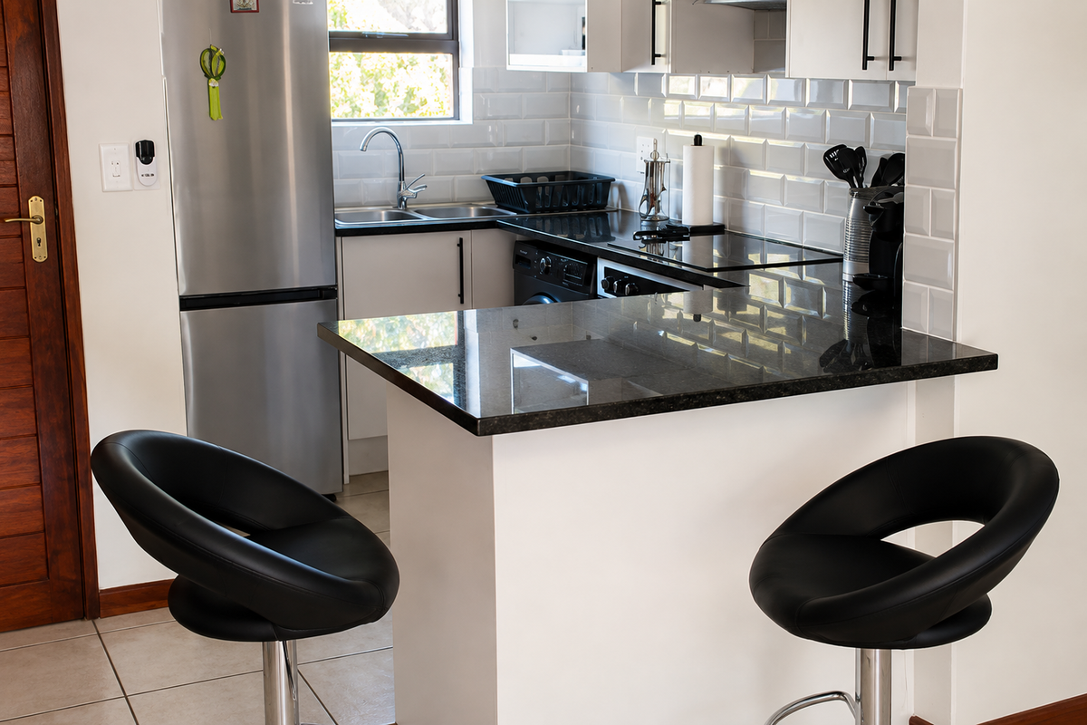 Modern kitchen featuring granite countertops, subway tile backsplash, and built-in cabinetry with a breakfast bar area.
