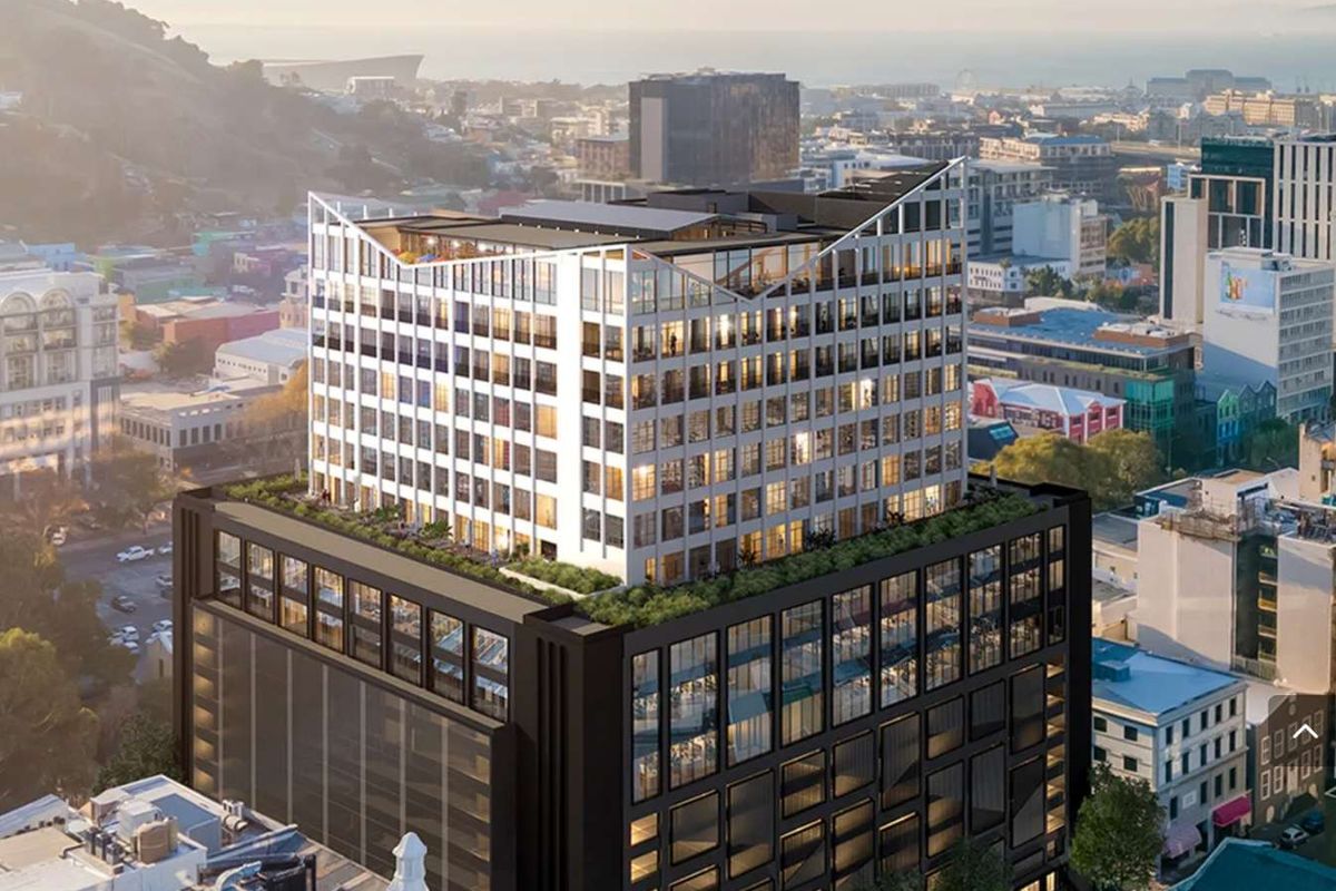 An aerial perspective of a modern multi-story office building featuring a distinctive rooftop terrace, glass facade, and integrated parking facilities in an urban setting.