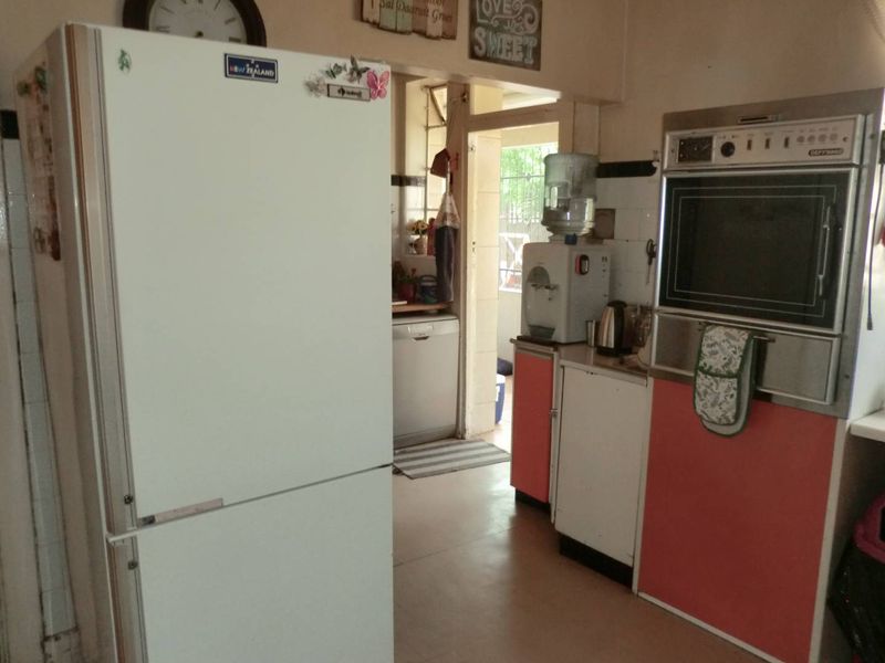 A dated kitchen featuring built-in oven and cabinetry, offering potential for modernization and renovation to improve functionality and aesthetic appeal.