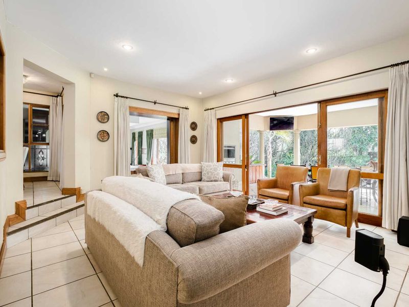 Spacious living room featuring tiled flooring, recessed lighting, and large sliding glass doors that provide seamless access to the outdoor patio area.