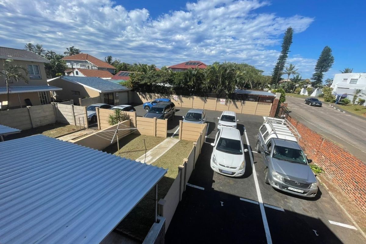 Aerial view of the townhouse complex parking area, featuring paved driveways, precast boundary walls, and a small private garden space.