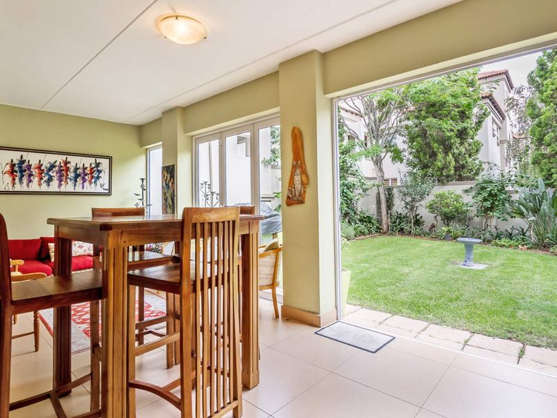 Bright open-plan living area featuring tiled flooring and large sliding glass doors that provide seamless access to the private rear garden.