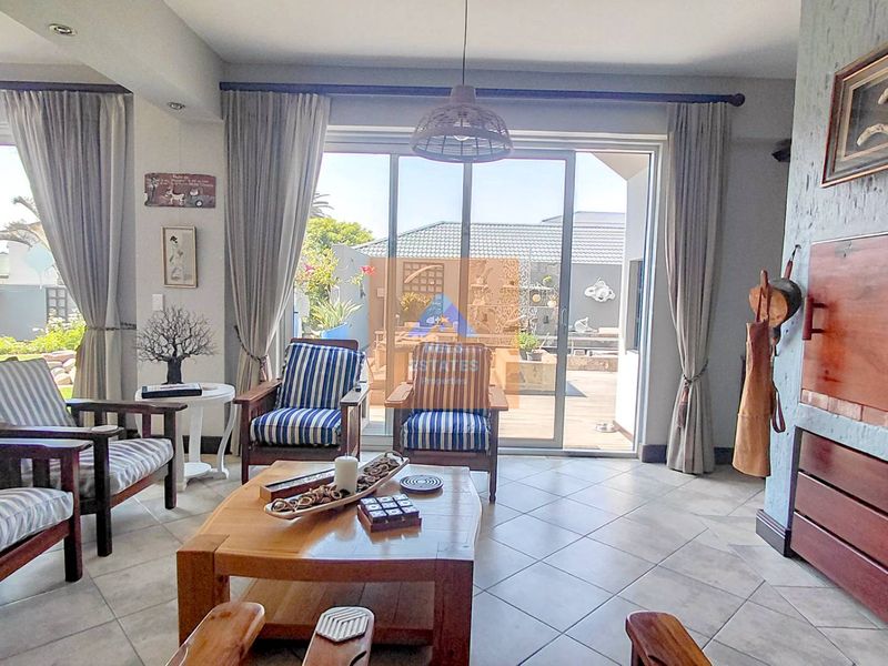 A bright living room featuring tiled flooring, a built-in fireplace, and large sliding glass doors that provide direct access to the outdoor patio area.