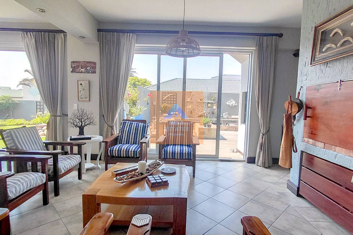 A bright living room featuring tiled flooring, a built-in fireplace, and large sliding glass doors that provide direct access to the outdoor patio area.