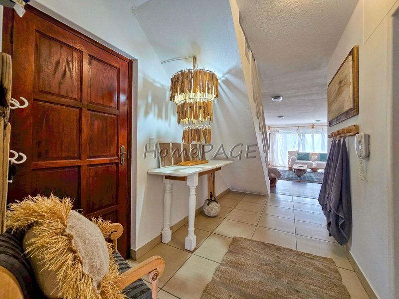 Welcoming entrance hall featuring ceramic floor tiles, a solid timber front door, and direct access to the main living area.