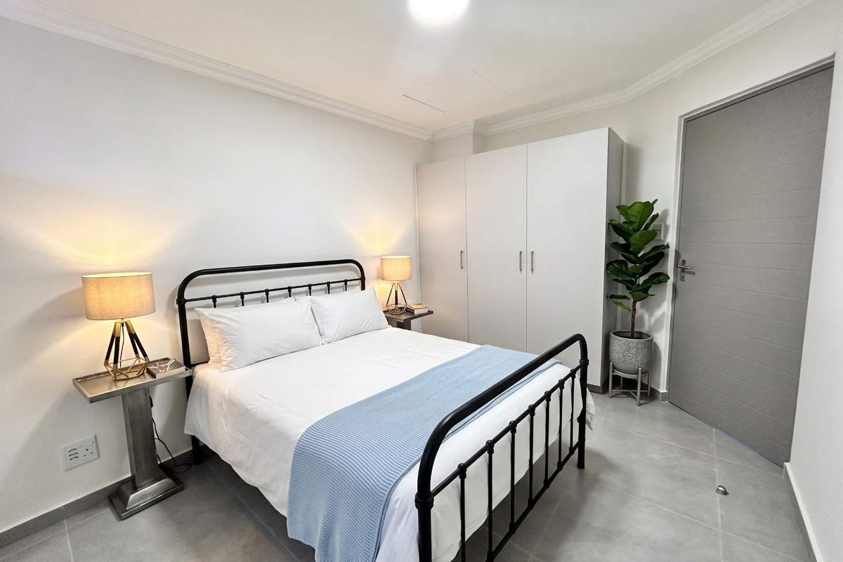 A well-maintained bedroom featuring neutral tiled flooring, built-in wardrobe storage, and clean finishes, providing a comfortable and functional living space.