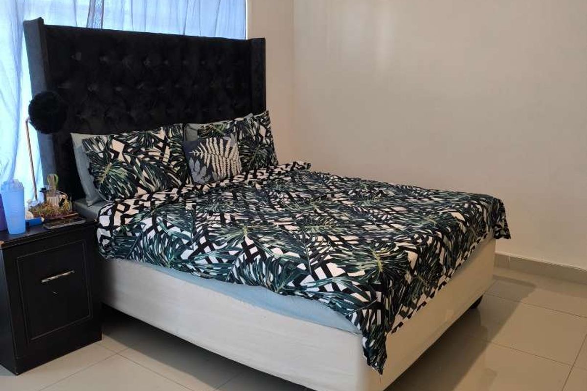 A bedroom featuring tiled flooring and a window with curtain tracks.